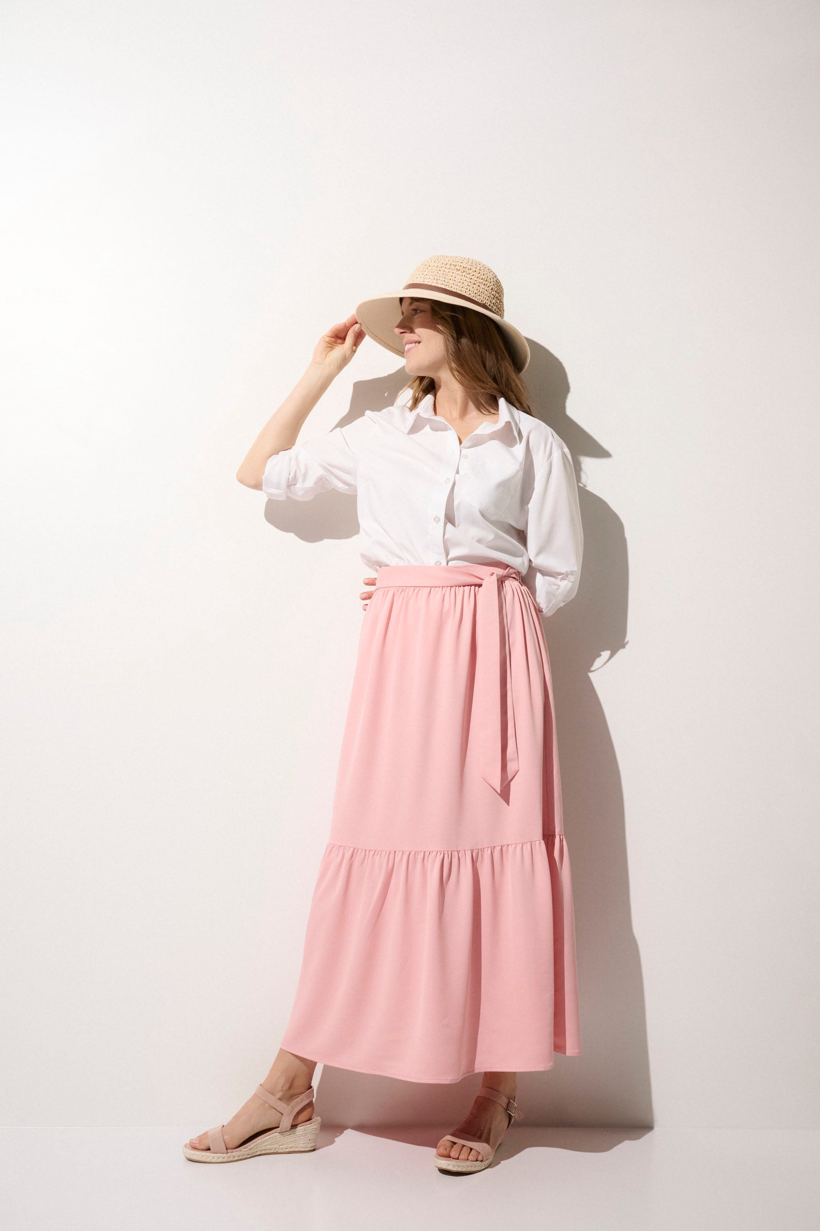 Jupe longue anti-UV rose, UPF50+, portée par une femme avec chapeau, idéale pour se protéger du soleil.