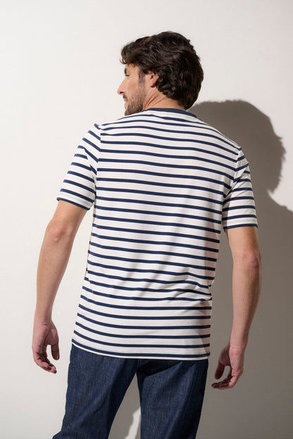 Homme portant un t-shirt anti-UV rayé blanc et bleu UPF50+, confortable pour une journée ensoleillée.