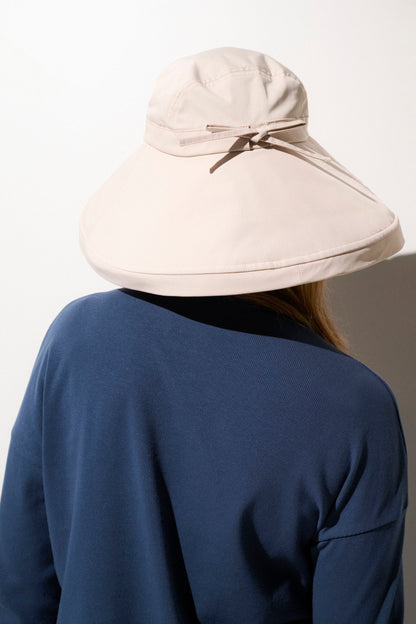 Chapeau anti-UV beige à large bord, parfait pour les activités extérieures, offrant protection solaire UPF 50+.