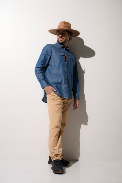 Homme portant un chapeau anti-UV UPF50+ et une chemise en denim, parfait pour une journée ensoleillée.