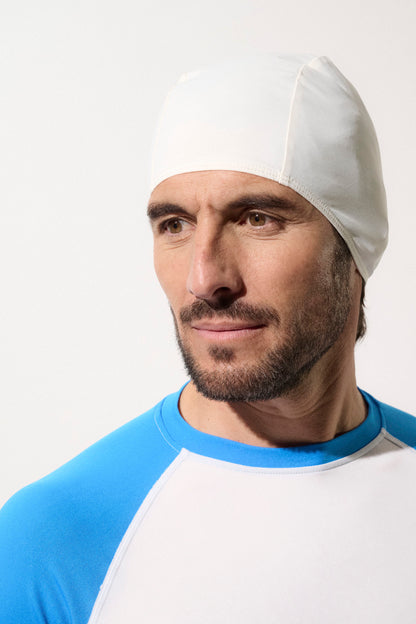 Bonnet de bain anti-UV blanc UPF50+ pour homme, idéal pour la protection solaire lors des activités aquatiques.