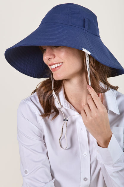 Chapeau anti-UV bleu pour femme, offrant une protection solaire avec un large bord et une jugulaire ajustable.