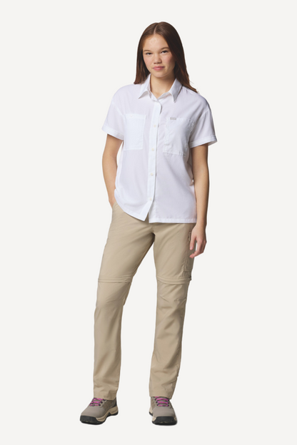 Femme portant une chemise anti-UV blanche Columbia, légère et respirante, certifiée UPF50+, idéale pour l'extérieur.