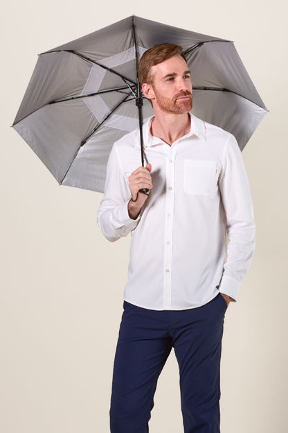 Homme tenant une ombrelle anti-UV UPF50+ sous une chemise légère, idéale pour la protection solaire en extérieur.